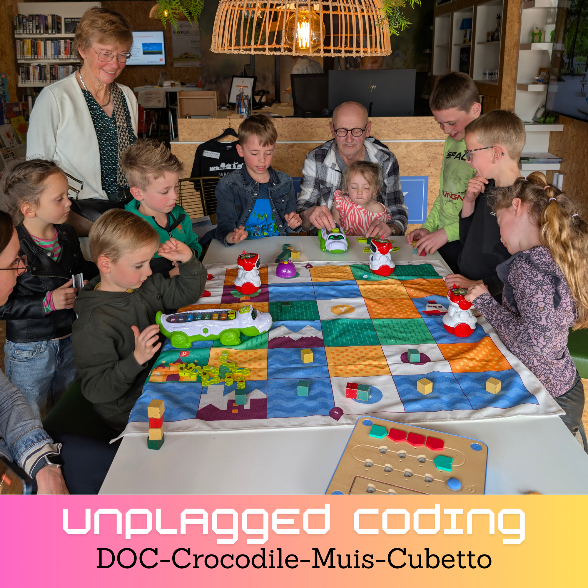 Groep kinderen en ouderen speelt samen een programmeerspel met robotfiguren op een speelkleed